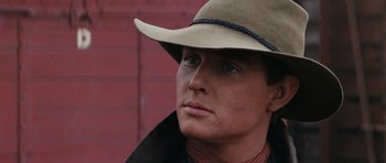 Movie still from “The Man from Snowy River” (1982), directed by George Miller – A person wearing a cowboy hat; Close Up shot, Over the shoulder angle