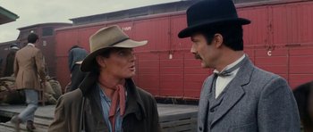 Movie still from “The Man from Snowy River” (1982), directed by George Miller – A man and a woman wearing cowboy hats; Medium shot, Over the shoulder angle