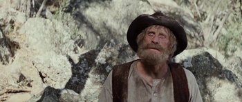 Movie still from “The Man from Snowy River” (1982), directed by George Miller – An old man with a long beard wearing a cowboy hat; Close Up shot, Low angle