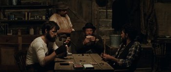 Movie still from “The Man from Snowy River” (1982), directed by George Miller – A group of men sitting around a table playing cards; Medium shot, High angle