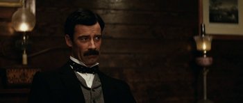 Movie still from “The Man from Snowy River” (1982), directed by George Miller – A person wearing a suit and tie; Close Up shot, Low angle