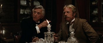 Movie still from “The Man from Snowy River” (1982), directed by George Miller – Two men sitting at a table with a lit candle; Close Up shot, Over the shoulder angle