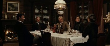 Movie still from “The Man from Snowy River” (1982), directed by George Miller – A group of people sitting at a dinner table; Wide shot, Over the shoulder angle