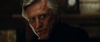 Movie still from “The Man from Snowy River” (1982), directed by George Miller – An older man with white hair looking at the camera; Close Up shot, Over the shoulder angle