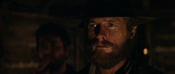 Movie still from “The Man from Snowy River” (1982), directed by George Miller – A man with a long beard and a hat on; Close Up shot, Low angle