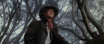 Movie still from “The Man from Snowy River” (1982), directed by George Miller – A man wearing a cowboy hat and a coat; Medium shot, Low angle