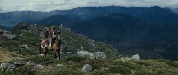 Movie still from “The Man from Snowy River” (1982), directed by George Miller – A man riding a horse on top of a hill; Extreme Wide shot, High angle