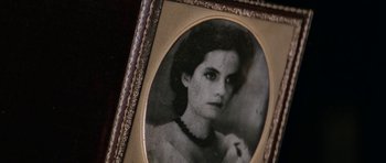 Movie still from “The Man from Snowy River” (1982), directed by George Miller – An old photo of a woman in a black and white picture; Extreme Close Up shot, High angle