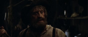 Movie still from “The Man from Snowy River” (1982), directed by George Miller – An old man with a beard wearing a hat; Close Up shot, Over the shoulder angle