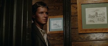 Movie still from “The Man from Snowy River” (1982), directed by George Miller – A man standing in front of a mirror in a room; Close Up shot, Low angle