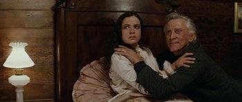 Movie still from “The Man from Snowy River” (1982), directed by George Miller – A man and a woman sitting on a bed; Medium shot, High angle