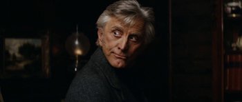 Movie still from “The Man from Snowy River” (1982), directed by George Miller – An older man with grey hair stares into the camera; Close Up shot, Over the shoulder angle