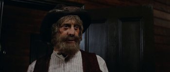 Movie still from “The Man from Snowy River” (1982), directed by George Miller – An old man with a beard and a hat; Close Up shot, Low angle