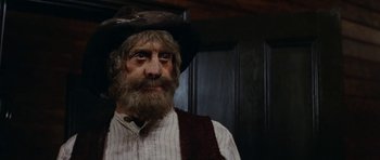 Movie still from “The Man from Snowy River” (1982), directed by George Miller – An old man with a beard wearing a pirate hat; Close Up shot, Low angle