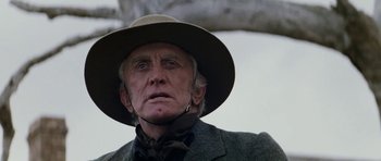 Movie still from “The Man from Snowy River” (1982), directed by George Miller – An old man wearing a hat and a jacket; Close Up shot, Low angle
