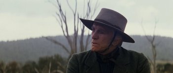 Movie still from “The Man from Snowy River” (1982), directed by George Miller – A man wearing a hat and a jacket; Close Up shot, Low angle