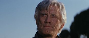 Movie still from “The Man from Snowy River” (1982), directed by George Miller – An older man with white hair and blue eyes looking at the camera; Close Up shot, Low angle