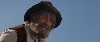 Movie still from “The Man from Snowy River” (1982), directed by George Miller – An old man with a long beard wearing a cowboy hat; Close Up shot, Low angle