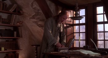 Movie still from “The Man in the Iron Mask” (1998), directed by Randall Wallace – A man is standing in front of an open book; Medium shot, Low angle