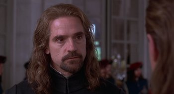 Movie still from “The Man in the Iron Mask” (1998), directed by Randall Wallace – A person with long hair and a beard; Close Up shot, Over the shoulder angle