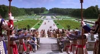 Movie still from “The Man in the Iron Mask” (1998), directed by Randall Wallace – A group of people standing on steps near a park; Extreme Wide shot, High angle