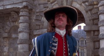 Movie still from “The Man in the Iron Mask” (1998), directed by Randall Wallace – A man dressed in medieval clothing and a hat; Medium shot, Low angle