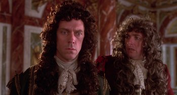 Movie still from “The Man in the Iron Mask” (1998), directed by Randall Wallace – A man and a woman wearing long curly hair; Close Up shot, Over the shoulder angle