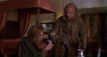 Movie still from “The Man in the Iron Mask” (1998), directed by Randall Wallace – A man in a pirate costume is holding a cup; Medium shot, Over the shoulder angle