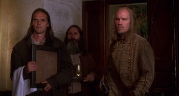 Movie still from “The Man in the Iron Mask” (1998), directed by Randall Wallace – A group of men standing next to each other in a room; Medium shot, Low angle