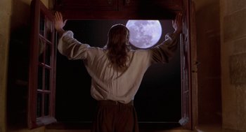 Movie still from “The Man in the Iron Mask” (1998), directed by Randall Wallace – A man standing in front of a window with a full moon in the background; Medium shot, Low angle