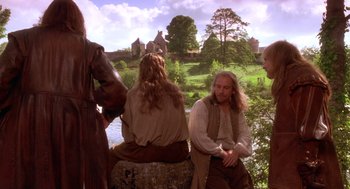 Movie still from “The Man in the Iron Mask” (1998), directed by Randall Wallace – A group of people sitting next to a body of water; Medium shot, Over the shoulder angle