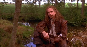 Movie still from “The Man in the Iron Mask” (1998), directed by Randall Wallace – A man sitting on the side of a river; Medium shot, Over the shoulder angle