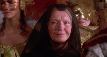 Movie still from “The Man in the Iron Mask” (1998), directed by Randall Wallace – An older woman wearing a black headscarf and a black veil; Close Up shot, Over the shoulder angle
