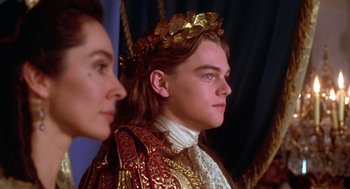 Movie still from “The Man in the Iron Mask” (1998), directed by Randall Wallace – A man in a gold crown and a woman in a red dress; Close Up shot, Low angle