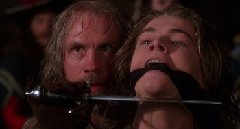 Movie still from “The Man in the Iron Mask” (1998), directed by Randall Wallace – A man and a woman tied to a metal bar; Close Up shot, Low angle