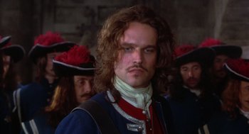 Movie still from “The Man in the Iron Mask” (1998), directed by Randall Wallace – A person with long hair and a beard; Close Up shot, Over the shoulder angle