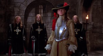 Movie still from “The Man in the Iron Mask” (1998), directed by Randall Wallace – A woman in a medieval outfit standing in front of two other men; Medium shot, Low angle