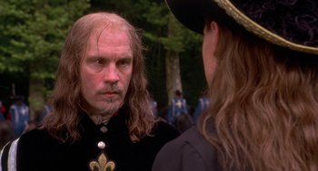 Movie still from “The Man in the Iron Mask” (1998), directed by Randall Wallace – A man with long hair wearing a black shirt; Close Up shot, Over the shoulder angle