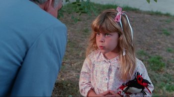 Movie still from “The Man with Two Brains” (1983), directed by Carl Reiner – A little girl with a pink bow in her hair; Close Up shot, Over the shoulder angle