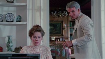 Movie still from “The Man with Two Brains” (1983), directed by Carl Reiner – An older man and a young woman in a living room; Medium shot, Over the shoulder angle