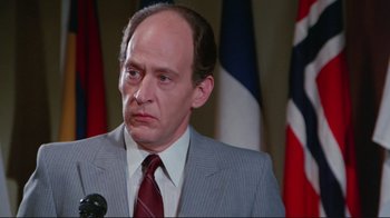 Movie still from “The Man with Two Brains” (1983), directed by Carl Reiner – A man in a gray suit and a red tie; Close Up shot, Low angle