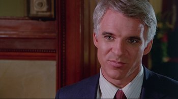 Movie still from “The Man with Two Brains” (1983), directed by Carl Reiner – A man in a suit and tie; Close Up shot, Over the shoulder angle