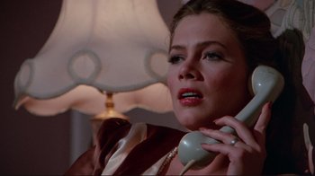 Movie still from “The Man with Two Brains” (1983), directed by Carl Reiner – A woman talking on a phone while sitting at a table; Close Up shot, Low angle