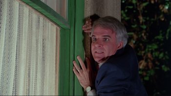 Movie still from “The Man with Two Brains” (1983), directed by Carl Reiner – An older man leaning against a green wall; Close Up shot, Low angle