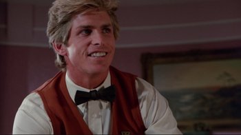 Movie still from “The Man with Two Brains” (1983), directed by Carl Reiner – A man in a vest and bow tie smiling for the camera; Close Up shot, Low angle