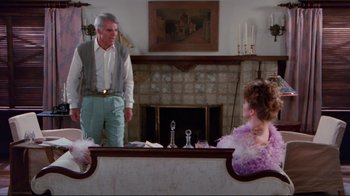 Movie still from “The Man with Two Brains” (1983), directed by Carl Reiner – An older man and a young woman are sitting at a table; Wide shot, Over the shoulder angle