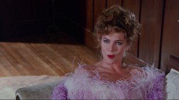 Movie still from “The Man with Two Brains” (1983), directed by Carl Reiner – A woman in a pink dress with a curly hair style; Close Up shot, Over the shoulder angle