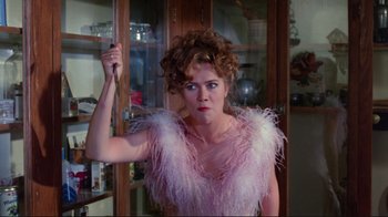 Movie still from “The Man with Two Brains” (1983), directed by Carl Reiner – A woman in a pink dress holding a sword; Close Up shot, Over the shoulder angle