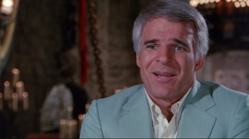 Movie still from “The Man with Two Brains” (1983), directed by Carl Reiner – A man in a blue suit and white shirt; Close Up shot, Over the shoulder angle