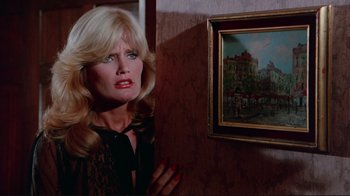 Movie still from “The Man with Two Brains” (1983), directed by Carl Reiner – A woman standing in front of a painting in a room; Close Up shot, Over the shoulder angle